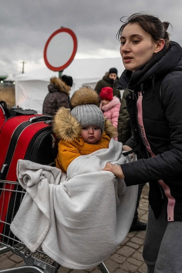 A refugee mother fleeing Russian invasion of Ukraine with her baby in a shopping cart February 27, 2022